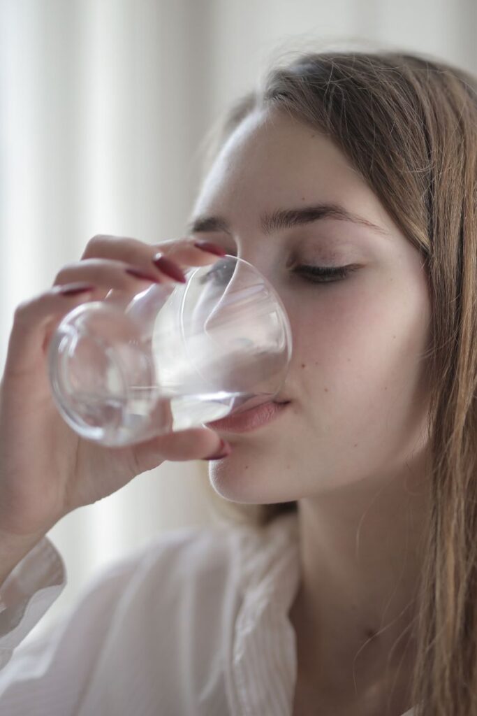 Woman Drinking water because of waking up with a dry mouth
