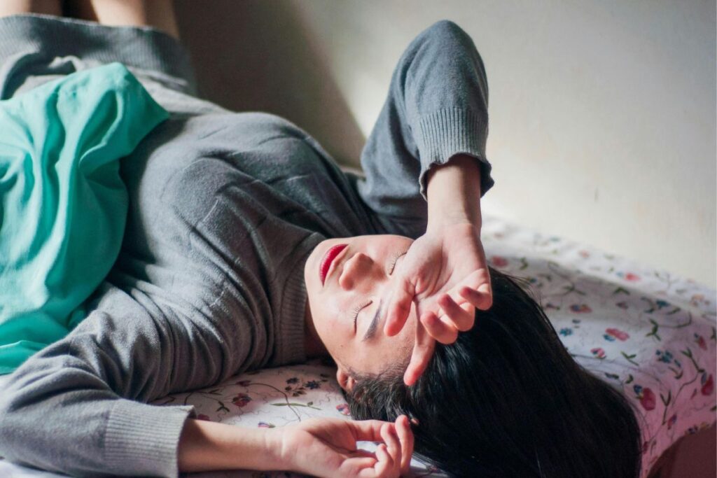 Wake up feeling exhausted, woman awake in bed feeling physically and mentally drained after poor sleep.