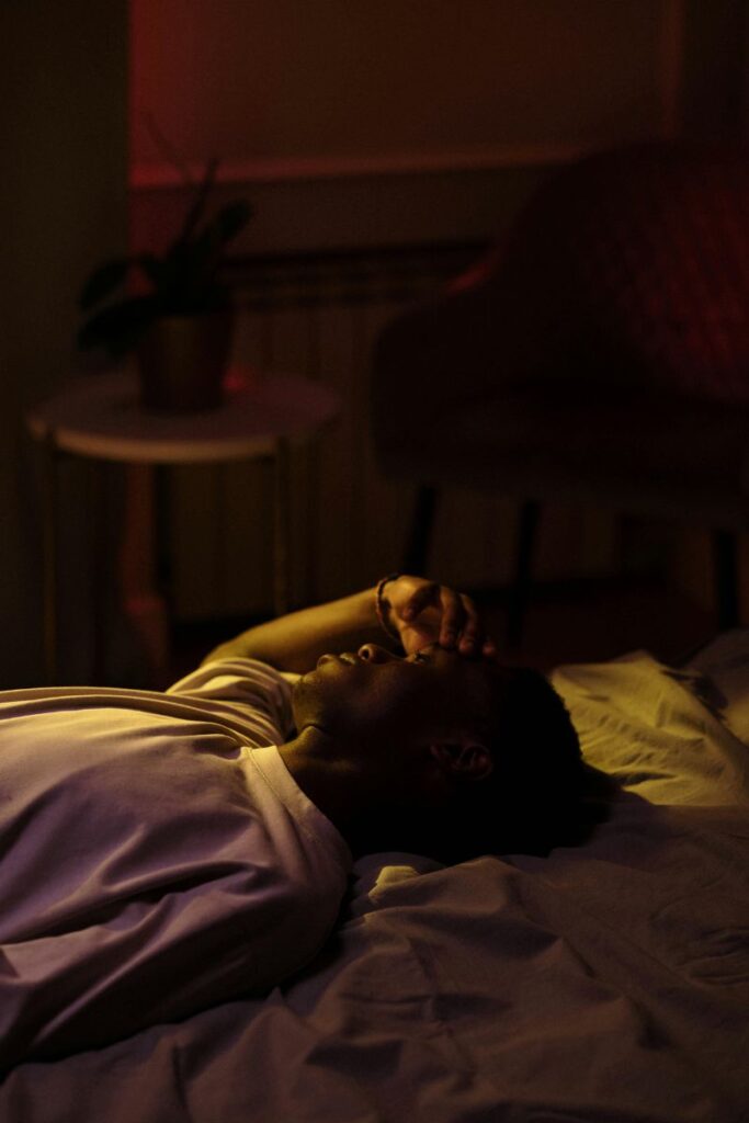 Why can`t my brain switch off at night - person lying awake in bed with racing thoughts before sleep.