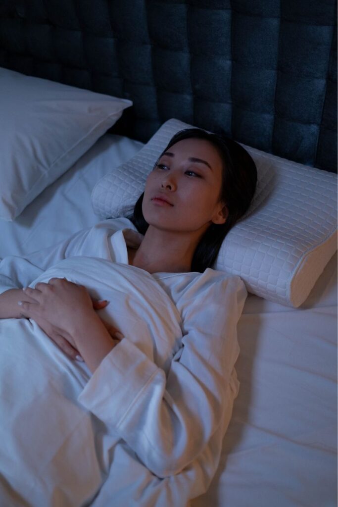 Woman lying in bed and she can`t fall back asleep she only thinks of being able to sleep.