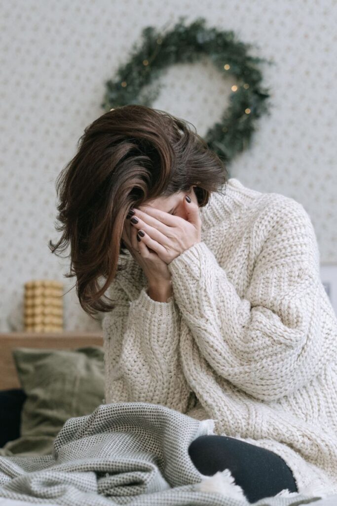 Woman sitting on the bed because of morning dizziness
